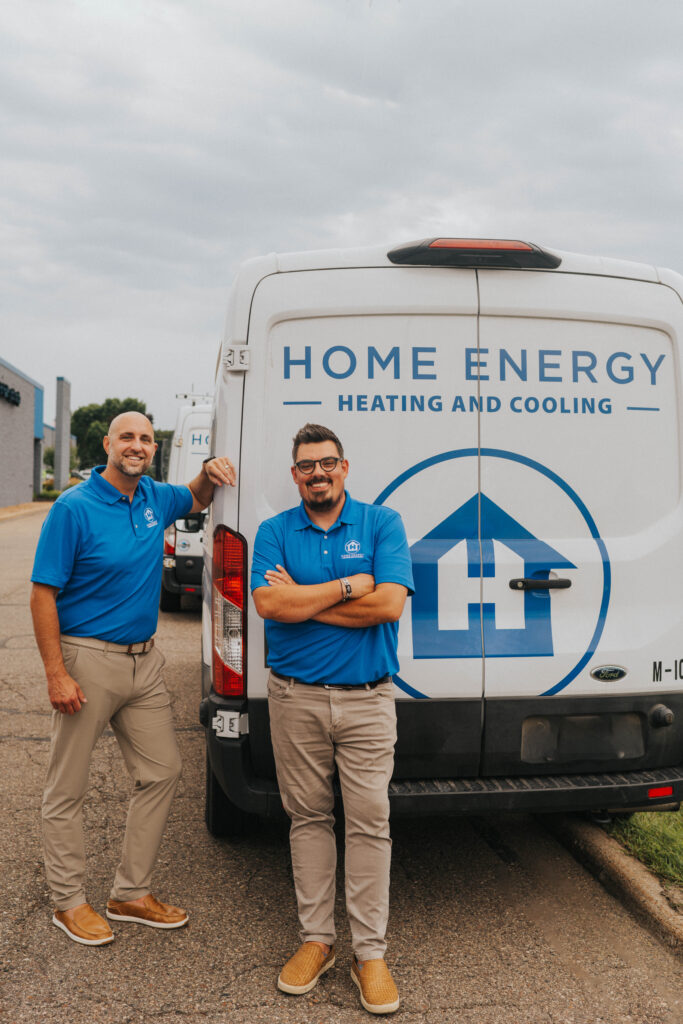 two employees in front of work van